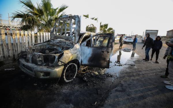 Palestinians are standing next to a vehicle in Deir Al-Balah, in the central Gaza Strip, on April 2, 2024, wher<em></em>e employees from the World Central Kitchen (WCK), including foreigners, were killed in an Israeli airstrike, according to the NGO. The Israeli military is stating that it is co<em></em>nducting a thorough review at the highest levels to understand the circumstances of this ''tragic'' incident, amid the o<em></em>ngoing co<em></em>nflict between Israel and Hamas. (Photo by Yasser Qudihe / Middle East Images / Middle East Images via AFP)