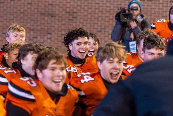 Byron senior Ashton Henkel (5), center, laughs as he and his teammates listen to their coaches for one last post-game huddle after beating downstate Mt. Carmel in the Class 3A state champio<em></em>nship game at Hancock Stadium in Normal on Nov. 24, 2023.