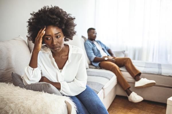 Unhappy Couple After an Argument in the Living Room at Home. Sad Pensive Young Girl Thinking of Relatio<em></em>nships Problems Sitting on Sofa With Offended Boyfriend, Co<em></em>nflicts in Marriage,