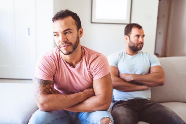mixed race gay couple on the couch havin<em></em>g a fight