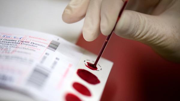 Nurse drops blood sample o<em></em>nto white card