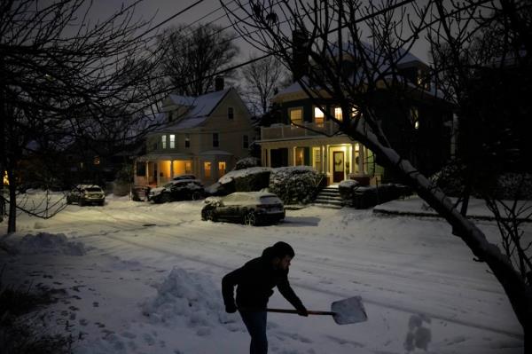 Colin Ladd clears snow from the sidewalk in front of his house Sunday, Jan. 7, 2024, in Providence, R.I.