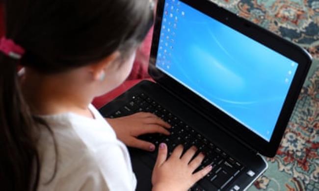 A photograph of a child using a laptop