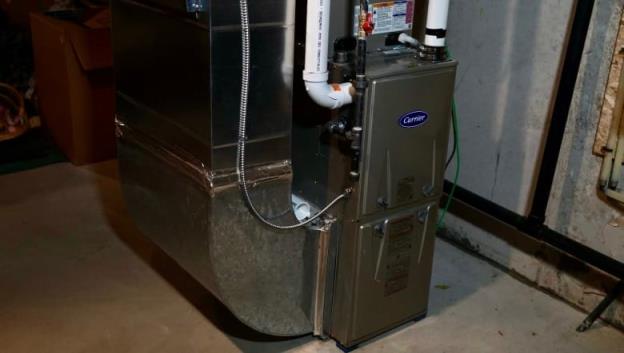 A furnace unit is seen in a ba<em></em>sement setting.