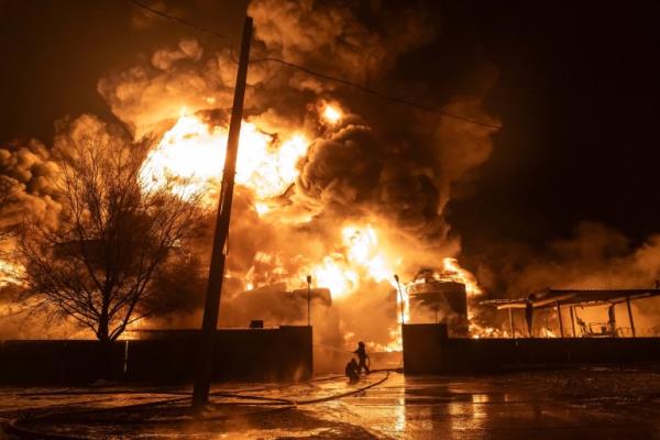 Firefighters at the petrol station thst was hit in a Russian attack. There are towering orange flames