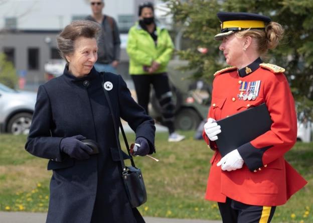 A woman wearing a dark blue coat walks alo<em></em>ngside a uniformed member of the Royal Canadian Mounted Police 