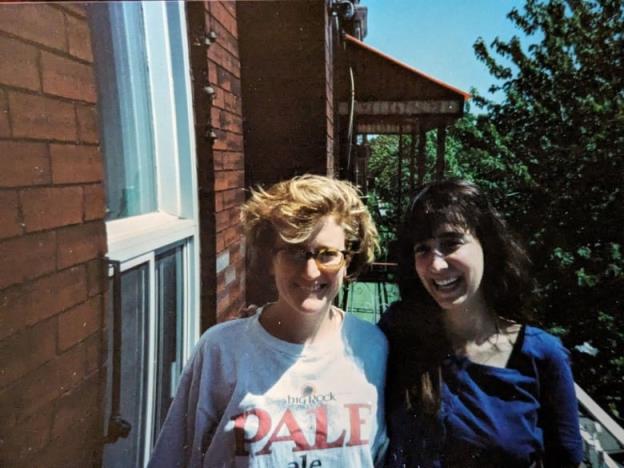 An old photo of two women pictured outdoors on a balcony.