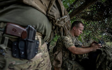 A Ukrainian serviceman operates a drone on the front line near the village of Robotyne