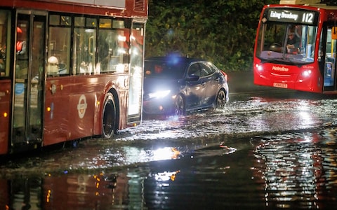 Traffic ploughs through flood water at Brent Cross in north London