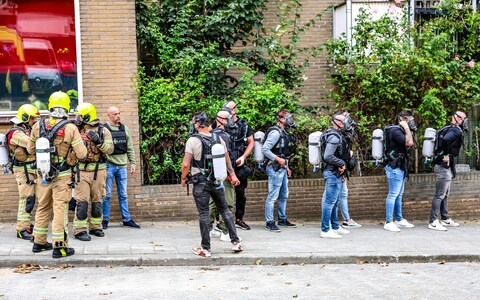 Emergency services prepare to enter a burning building, following three shootings in Rotterdam