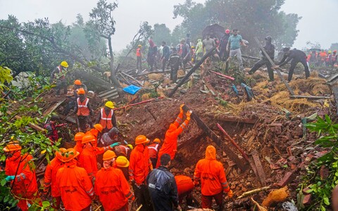 Rescuers work at the site of a landslide in which 16 have died and a<em></em>bout 50 more are feared trapped under debris