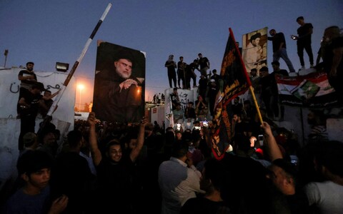 Demo<em></em>nstrators carry signs of Shia cleric Muqtada al-Sadr 