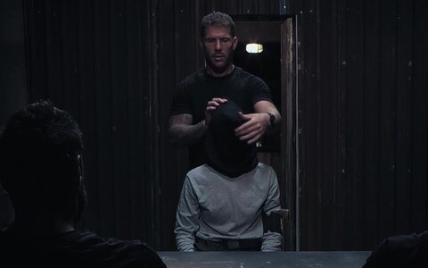 Mr Hancock with a hood over his head for his grilling