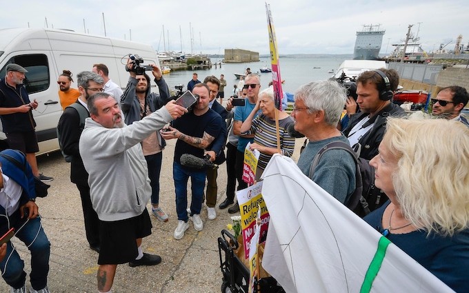 抗议者在多塞特港迎接第一波驳船抵达