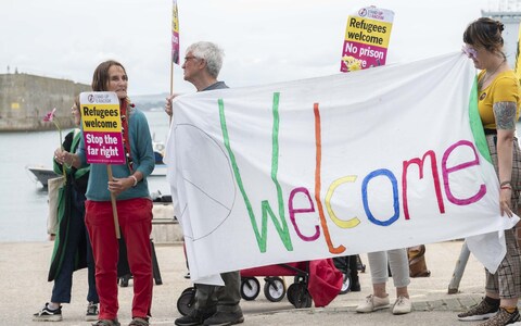 A group of supportive demo<em></em>nstrators welcome asylum-seekers as they are transferred to the Bibby Stockholm
