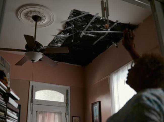 Darlene Jo<em></em>nes covers a hole in her ceiling with trash bags to help co<em></em>ntain air from leaking in and out of her house in New Orleans, Louisiana, on 12 November 2023.