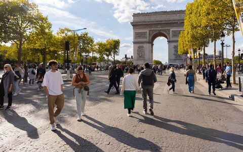 People walk on the Avenue des Champs Elysees during the 8th edition of Paris Respire the day without cars