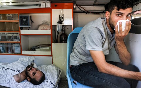 An injured man lies inside an ambulance waiting at the Rafah border crossing in the southern Gaza Strip