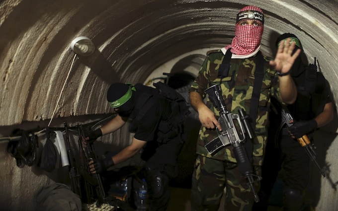 A Palestinian fighter from the Izz el-Deen al-Qassam Brigades, the armed wing of the Hamas movement, gestures inside an underground tunnel in Gaza