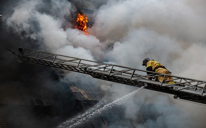 A fireman works to extinguish a burning building in Russian-occupied Do<em></em>netsk after it was hit by Ukrainian shelling