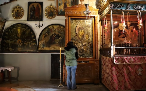 A woman prays at the empty Church of Nativity in Bethlehem