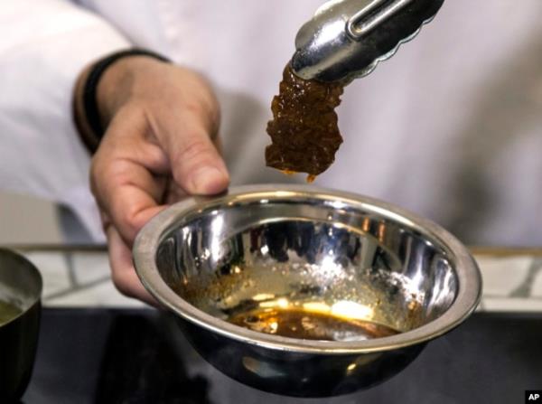 FILE - In this Jan. 16, 2019 photo, chef Amir Ilan prepares a lab-grown steak during a presentation by the company Aleph Farms, in Jaffa, Israel.