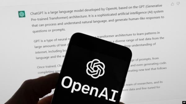 FILE - The OpenAI logo is seen on a mobile phone in front of a computer screen displaying output from ChatGPT. Experts say artificial intelligence will make investigative journalism easier, especially for smaller newsrooms.