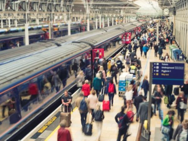 Horizo<em></em>ntal color image of a busy railroad platform at Paddington station in London, UK.