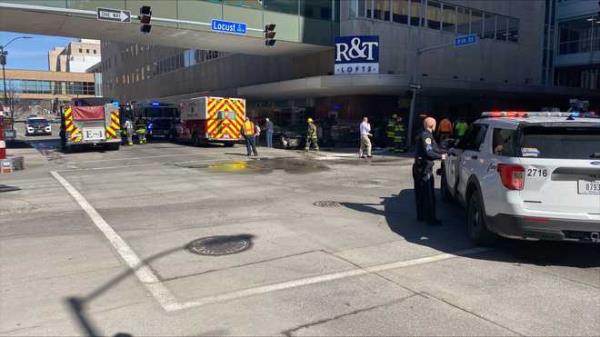 a car on its side rests next to r&t lofts in downtown des moines