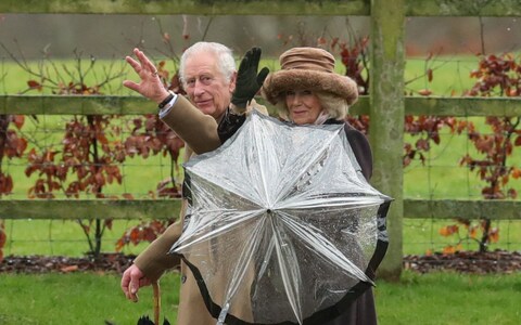 King Charles and Queen Camilla wave after attending a church service at St. Mary Magdalene's church on the Sandringham estate