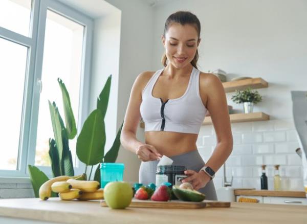 woman making protein drink, co<em></em>ncept of sneaky ways to build muscle without exercising