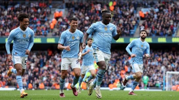 Jeremy Doku wheels away in celebration after his goal