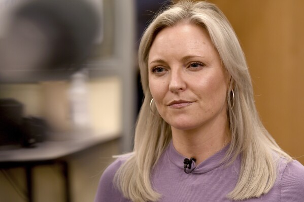 Heather Martin is interviewed in Aurora, Colo., on Thursday, April 11, 2024. Martin, a survivor of the 1999 shooting at Columbine High School in suburban Denver, hid with 60 other students in a barricaded office during the attack. It's been a quarter-century since two gunmen killed 12 fellow students and a teacher at the school, and the trauma of that day co<em></em>ntinues to shadow Martin and others who were there. (AP Photo/Thomas Peipert)