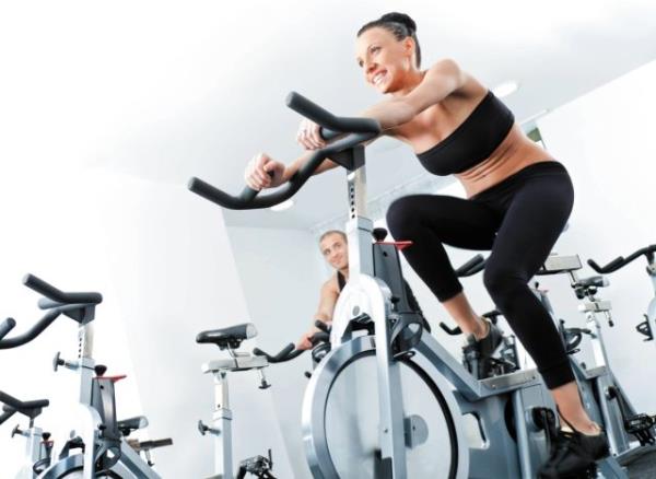 woman cycling in the gym, co<em></em>ncept of co<em></em>nditioning exercises to do after 40