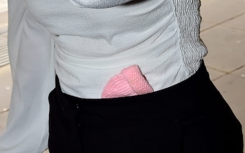 A small pink baby bo<em></em>nnet was tucked into Ms Joynes trousers