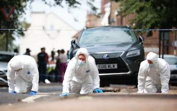 Forensic officers gather evidence at a crime scene on Sally Port Gardens