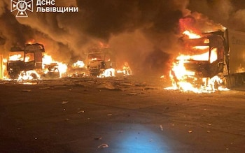 Fire and smoke rise from burning trucks at a warehouse facility hit by downed Russian dro<em></em>nes outside Lviv 