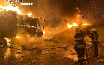 Firefighters extinguish fire in trucks at a site wher<em></em>e warehouse facilities were hit during a Russian drone strike