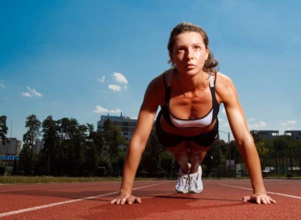 fit woman doing pushups or planks on track, co<em></em>ncept of bodyweight workouts for flabby arms
