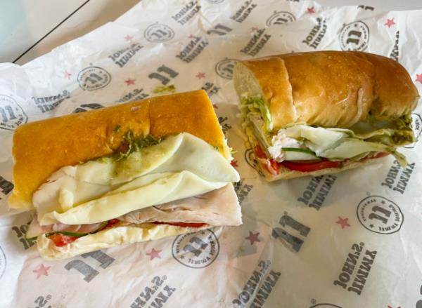 The Italian Night Club sandwich from Jimmy John's restaurant, set against a vibrant purple background.