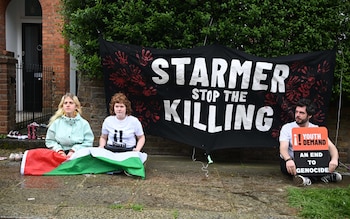 The demo<em></em>nstrators with a banner outside Sir Keir Starmer's house that reads 'Starmer stop the killing'