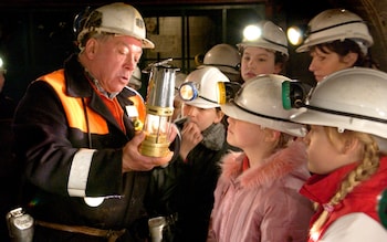 A former miner shows school pupils around The Big Pit Natio<em></em>nal Coal Museum