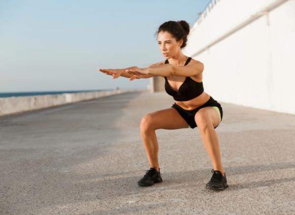 woman doing squats, co<em></em>ncept of five-minute exercises