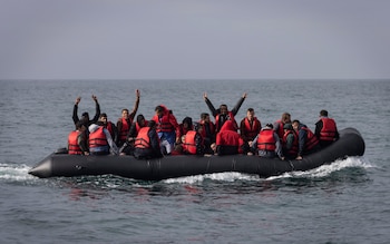 An inflatable craft carrying migrants crosses the shipping lane in the English Channel on August 4, 2022 off the coast of Dover, England
