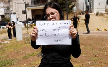 A woman holds a poster as she and others demo<em></em>nstrate against the Israeli prime minister's visit 