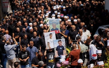 Druze elders and mourners surround the coffin of Guevara Ibrahim, 11, killed in a strike from Lebanon