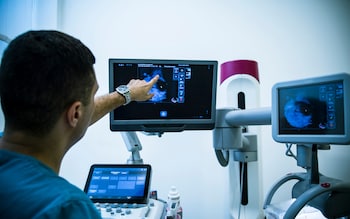 A stock image of a doctor using a mammogram