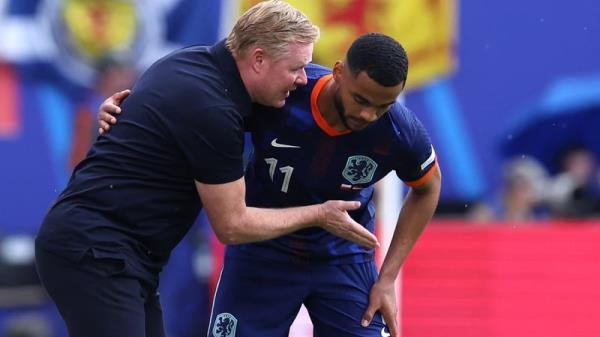 Netherlands' head coach Ro<em></em>nald Koeman (L) speaks with Netherlands' Cody Gakpo during the win over Poland