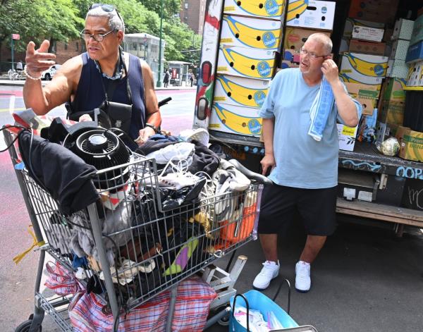 Street vendors with grocery cart filled with items for sale