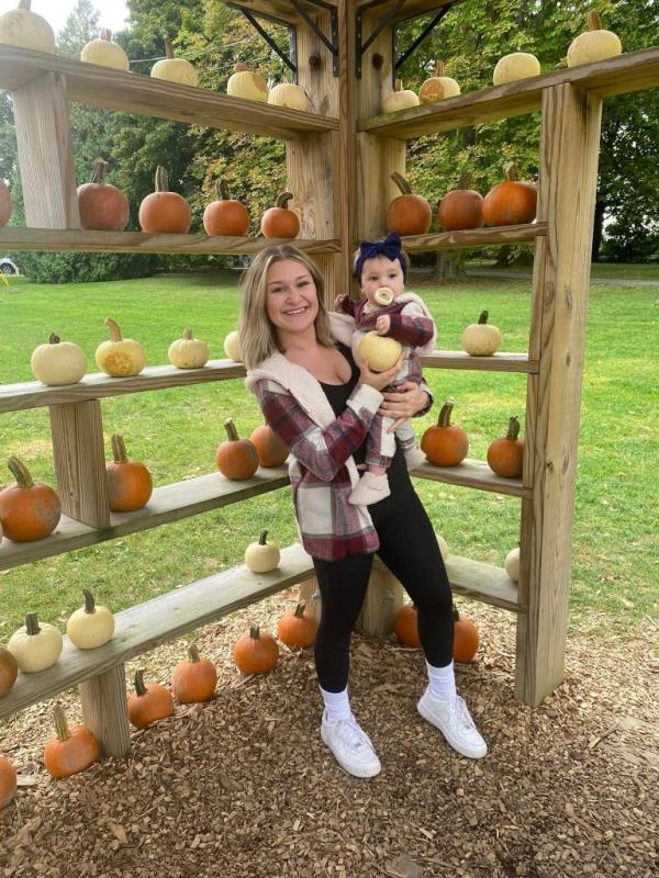 Iris with her mother Emily Alfera in coordinating outfits near pumpkins. 